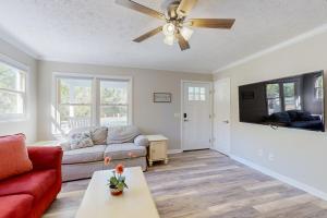 uma sala de estar com um sofá e uma ventoinha de tecto em The Grey Pearl em Ocean Isle Beach