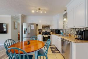 a kitchen with a wooden table and blue chairs at The Grey Pearl in Ocean Isle Beach