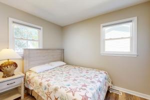 a small bedroom with a bed and a window at The Grey Pearl in Ocean Isle Beach