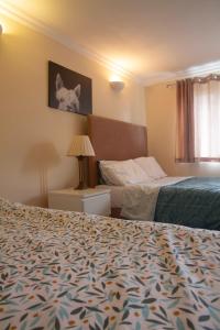 een hotelkamer met 2 bedden en een lamp en een bed bij Spacious & bright 4-bedroom town-house with garden in Sydenham
