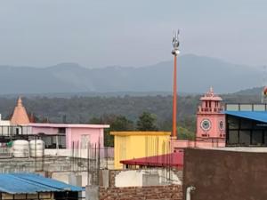 una torre dell'orologio e un edificio con orologio di Goroomgo Riddhi Siddhi Haridwar Near Railway Station - Best Seller a Haridwār