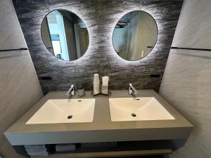 a bathroom with two sinks and two mirrors at Domaine Bless in Niki