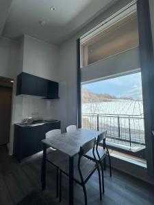 a kitchen with a table and chairs and a large window at Domaine Bless in Niki