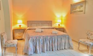 een slaapkamer met een bed met 2 stoelen en 2 lampen bij Greenery House in Empoli
