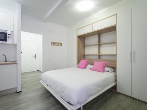 um quarto branco com almofadas cor-de-rosa numa cama em Empire Canteras By CanariasGetaway em Las Palmas de Gran Canaria