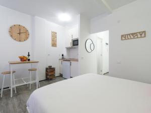 um quarto branco com uma cama e uma cozinha em Empire Canteras By CanariasGetaway em Las Palmas de Gran Canaria