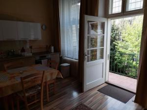 uma cozinha com uma mesa e uma porta para uma varanda em Apartment Corona em Košice