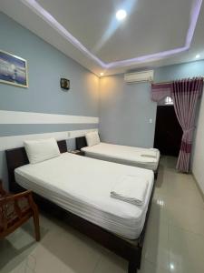 2 camas en una habitación pequeña con ventana en CÁT TƯỜNG MOTEL, en Da Nang