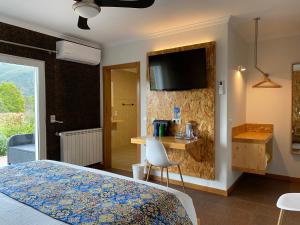 - une chambre avec un lit et une télévision murale dans l'établissement Casa Carvalhal, à Góis