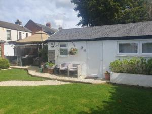 a white house with a white door and a yard at Sally's bed and breakfast in Luton