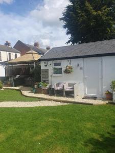 a white house with a bench in a yard at Sally's bed and breakfast in Luton