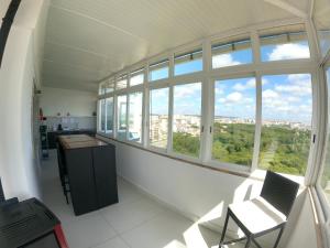 a room with a large window and a table and chairs at Almada apartamento T1 - 1 Renovado, Laranjeiro in Almada