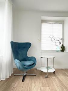 een blauwe stoel en een tafel in een kamer bij Haus am Deich 47 stilvolles Landhaus an der Elbe in Stadtnähe in Hamburg