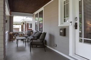 a porch with chairs and a table and windows at Cincy East Side Cottage the best of Hyde Park in Cincinnati