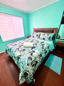 1 cama en un dormitorio con una pared azul en Casa sector residencial 3 dormitorios, en Puerto Montt
