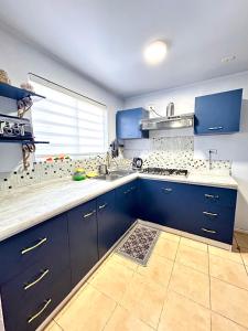 una cocina con armarios azules y fregadero en Casa sector residencial 3 dormitorios, en Puerto Montt
