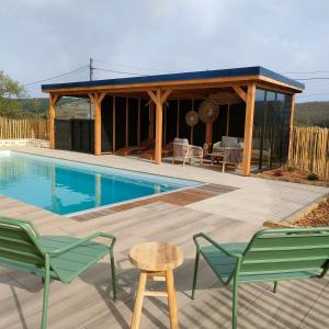 a pool house with a pavilion and chairs and a table at Chalet, aux portes du Morvan in Voudenay-lʼEglise