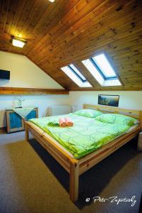 uma cama grande num quarto com tecto em madeira em Hotel Jef a Krčma u Rytíře em Doubice