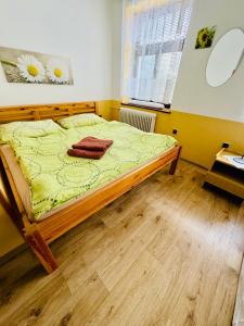 1 dormitorio con 1 cama con sábanas amarillas y ventana en Hotel Jef a Krčma u Rytíře en Doubice