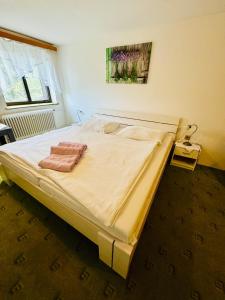 Una cama grande en un dormitorio con una toalla. en Hotel Jef a Krčma u Rytíře en Doubice