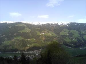 a view of a green valley with snow covered mountains at Apart Tiefenbach in Aschau