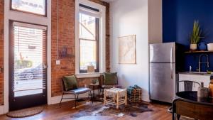 a kitchen with a refrigerator and a table and chairs at Central Urban Flat - Near the Best of Covington in Covington
