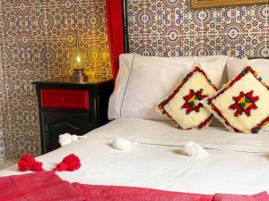 Una cama blanca con dos almohadas encima. en Dar Statia 4 vue mer cité portugaise, en El Jadida