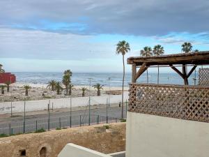 uma vista para uma praia com palmeiras e para o oceano em Dar Statia 4 vue mer cité portugaise em El Jadida