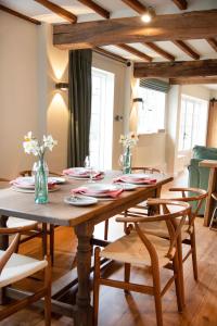 a dining room with a wooden table and chairs at Mousehall Oast in Wadhurst