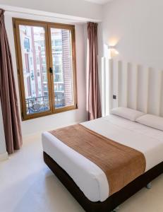 1 dormitorio con cama y ventana en Hostal Gran Via 44, en Madrid