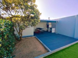a blue patio with a table and a tree at CasinhaDaPraia in Aguçadoura