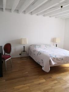 1 dormitorio con 1 cama, 1 silla y 2 lámparas en Maison de famille piscine et vue, en Sougères-en-Puisaye