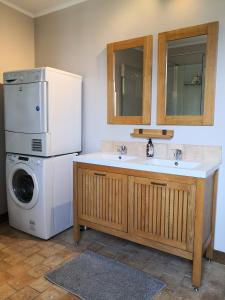 cocina con nevera y lavadora en Maison de famille piscine et vue, en Sougères-en-Puisaye