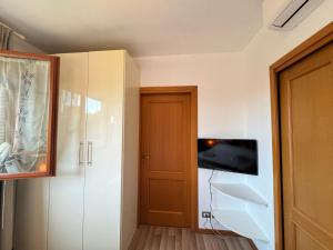 a room with a tv on a wall and a door at Flower Garden House in Rome