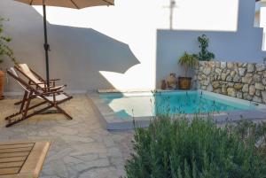 a swimming pool with a chair and an umbrella at Anassa Mountain House in Émbonas