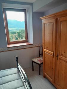 a bedroom with a window and a bed and a chair at la fontaine bénite in Seyssel