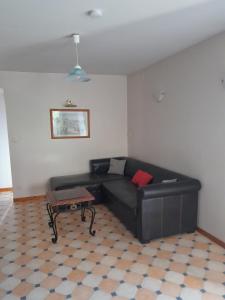 a living room with a black couch and a table at la fontaine bénite in Seyssel