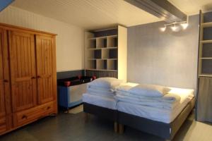 - une chambre avec un lit doté d'oreillers blancs et d'un placard dans l'établissement Maison familiale pour 10 personnes au centre à St Georges d'Oleron, à Saint-Georges-dʼOléron