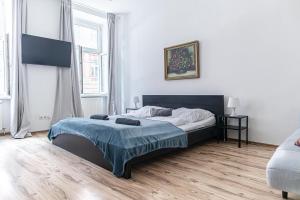 a bedroom with a bed with a blue blanket on it at Budget Apartments Well connected to the Whole City in Vienna