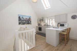 a kitchen with white cabinets and a white counter top at Black Lion Court in Little Walsingham