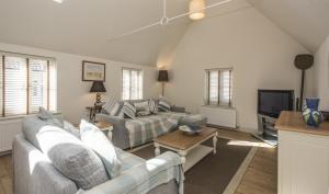 a living room with two couches and a tv at Black Lion Court in Little Walsingham