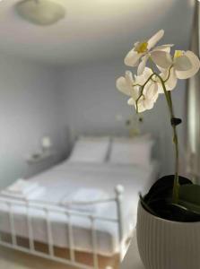 a white flower in a vase on a table next to a bed at Summer Sea Home in Nerátza