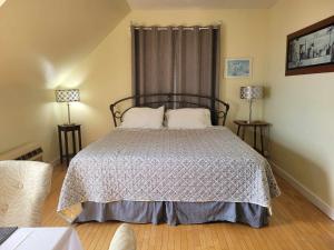 a bedroom with a bed and two lamps on tables at Auberge Vue d'la Dune - Dune View Inn in Bouctouche