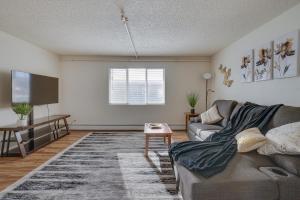 Cozy Anchorage Apartment with Mountain Views في أنكوراج: غرفة معيشة مع أريكة وتلفزيون بشاشة مسطحة