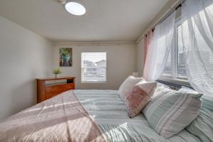 Cozy Anchorage Apartment with Mountain Views في أنكوراج: غرفة نوم بسرير ومخدات ونافذة
