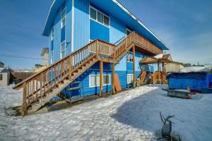 Cozy Anchorage Apartment with Mountain Views في أنكوراج: بيت ازرق مع درج خشبي في الثلج