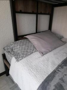 Una cama con sábanas blancas y almohadas. en Departamento Aeropuerto para 6, en Huejotzingo
