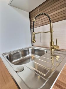 a stainless steel kitchen sink with a faucet at Appartement de charme avec balcon au pied des commerces in Béziers
