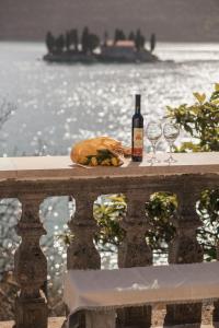 a table with a bottle of wine and two glasses at Step to Kotor bay Perast in Perast +36 photos