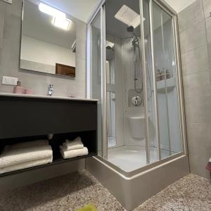 La salle de bains est pourvue d'une douche en verre et d'un lavabo. dans l'établissement TERRE AGRICOLAE B&B, à Marina